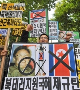 Jihokorejští aktivisté demonstrují proti KLDR a Kimovi.
