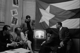 Skupinka kubánských uprchlíků sleduje Kennedyho proslov, 1962.