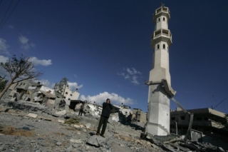 Hlas v pustině. Palestinec se hlasitě modlí u trosek kolem mešity.
