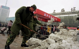 Čínští vojáci odklízejí sníh před šanghajským nádražím.