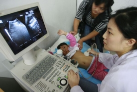 Lékařka hledá utrasonografem změny na ledvinách dítěte.