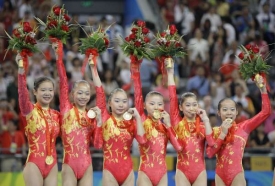 Čínské gymnastky pózují se zlatými medailemi, Che Kche-sin čvrtá zleva