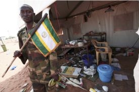 Příslušník sil Africké unie před zničeným vojenským táborem Haskanita