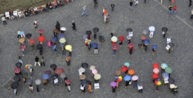 Lidé s deštníky na Staroměstském náměstí.
