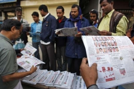 Bangladéšané čtou v novinách o výsledcích voleb.
