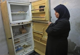 Palestinka se dívá do prazdné chladničky. Elektřina stejně nejde.r