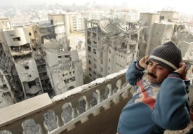 Muž se dívá na zničené vládní budovy ve městě Gaza.