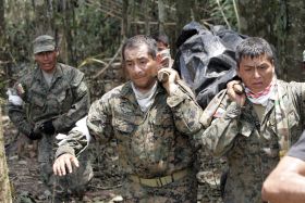 Ekvádorští vojáci odnášejí mrtvé povstalce z džungle v Angostuře.