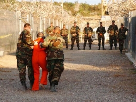 Jeden z vězněných na Guantanámu odváděn k výslechu.