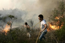 Místní z obce Leprio na jihu ostrova Peloponés bojují s plameny pomocí zahradní hadice.