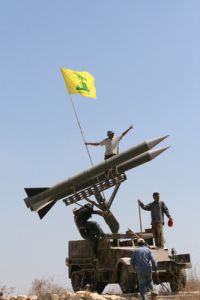 Příznivci Hizballáhu vztyčující jeho vlajku