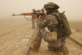Irácký voják na patrole v písečné bouři severně od Bagdádu.