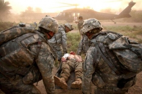 Vojáci USA odvážejí zraněného iráckého spolubojovníka (ilustrace).