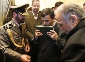 Ahmadínežád líbá korán před odletem do Saúdské Arábie (2008).