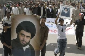 Muktada Sadr (vpředu) na obraze v rukou šíitských demonstrantů