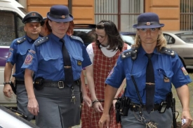 Eskorta přivádí tetu týraných chlapců Kateřinu Mauerovou před soud.