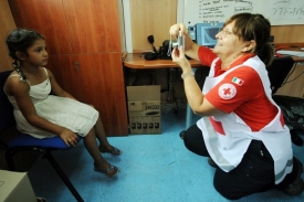Italská pracovnice Červeného kříže fotí romské dítě v rámci sčítání.