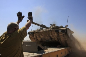Stop. Izraelci nakládají na tahač tank u hranic s Gazou.