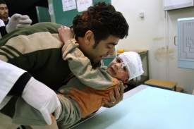 Palestinec přináší do nemocnice chlapce zraněného při bombardování.