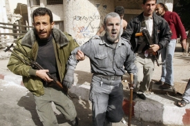 Zraněný policista Hamasu utíká z místa dopadu bomb.