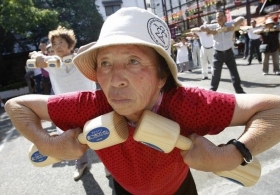 Japonka cvičí s činkami u kláštera u příležitosti Dne staších lidí.