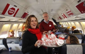 Šéf liberálů Dion schotí rozdává cukrlata ve volebním letadle.