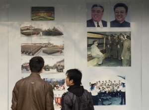 Kim Čong-il (vpravo) a Kim Il-sung na výstavce. Oba hlídali Francouzi.