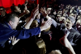 Vítěz kosovských voleb Hashim Thaçi (vpravo) podává ruku fanouškům.