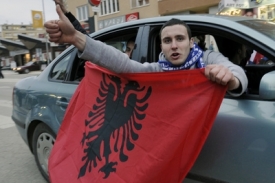 Kosovský Albánec v Prištině s albánskou vlajkou.