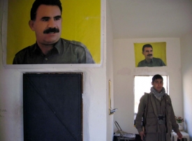 Jeden z rebelů Kudské strany pracujících před portrétem Abdullah Ocala