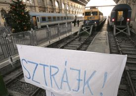 Transparent s nápisem stávka na vlakovém nádraží v Budapešti.