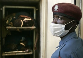 Nemocniční pracovník stojí u chladícího boxu s mrtvými těly.