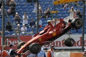 Ferrari Felipeho Massy se zdemolovanou zádí je odváženo mimo trať.