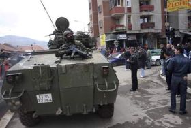 Mírové jednotky NATO v etnicky rozděleném městě Mitrovice.