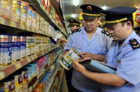 Policie pomáhá kontrolovat výrobky Sanlu v prodejnách.