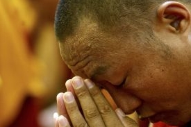 Tibetský mnich se modlí při protestu na tibetsko-nepálské hranici.