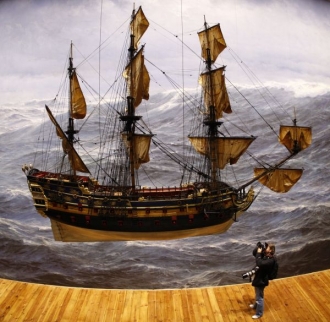 Novinář fotografuje model lodi.