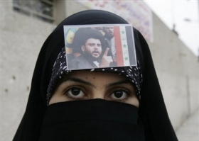 Iráčanka s fotografií radikálního šíitského duchovního Muktady Sadra.