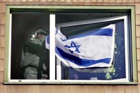 Policista strhává za jásotu za jásotu islamistů izarelskou vlajku.