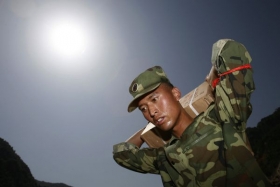 Čínský voják nese výbušninu k jezeru Tchang-ťia-šan.