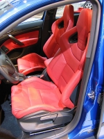 Interiéru dominují červené skořepinové sedačky.