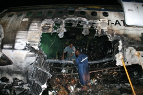 Záchranáři odklízejí trosky zničeného letadla.