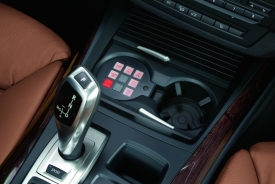 Ovládání speciálních funkcí vozu je šikovně umístěno v držáku na nápoje a lze ho zakrýt stejnou roletkou, jakou má jakékoliv jiné BMW X5.