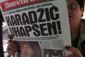 Bosenská žena čte v novinách o zadržení Karadžiče.