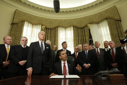 Obama v Oválné pracovně se svými ministry a viceprezidentem.