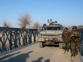 Kolona NATO a afghánští vojáci střeží nový most na jihu Afghánistánu.