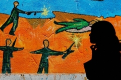 Palestinská dívka u malby znázorňující konflikt s Izraelem
