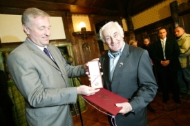 Premiér Topolánek předává plaketu Milanu Paumerovi.