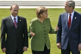 Merkelová mezi studenoválečníky Putinem a Bushem.
