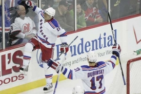 Hokejisté Rangers Žerděv a Dubinsky oslavují gól v síti New Jersey.